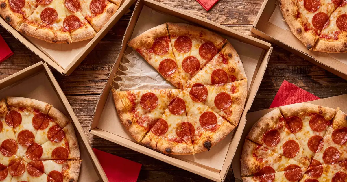 Four large pepperoni pizzas in open boxes, each cut into eight slices, the order a pizza party calculator plans